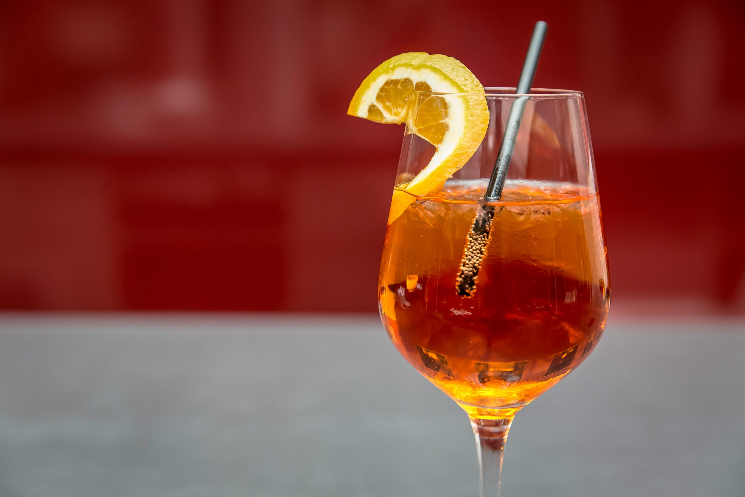 Bright Aperol spritz with lemon slice on a glass, perfect for summer refreshment.